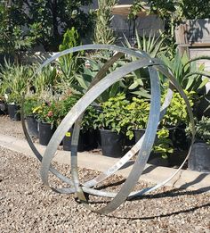 a metal sculpture sitting in the middle of a garden