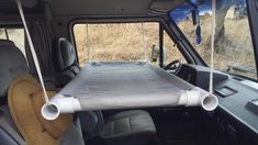 the back end of a vehicle with a mattress strapped to it's front seat