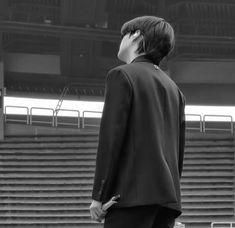 a man in a suit and tie looking up at the bleachers