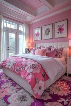 a bedroom decorated in pink and white with lots of flowers on the bed, along with two framed pictures