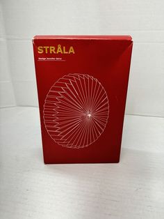 a red box with the word strala on it sitting on a white surface