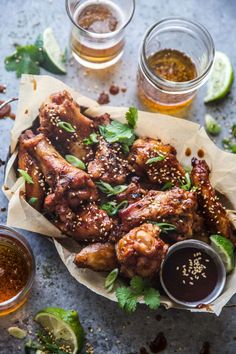 chicken wings with dipping sauces and lime wedges