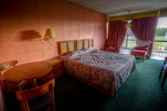 a hotel room with a bed, table and chairs