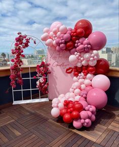 the balloon arch is decorated with pink, red and white balloons