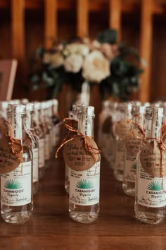 small bottles with labels tied to them on a table