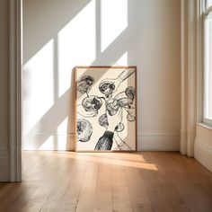 an art work is displayed on the floor in front of a window with sunlight streaming through it