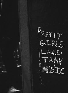 graffiti written on the side of a building next to a door with words that read pretty girls like trap music