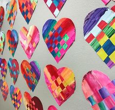 colorful paper hearts are hanging on the wall