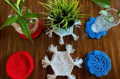 crocheted coasters and pot holders on a table with plants in the background