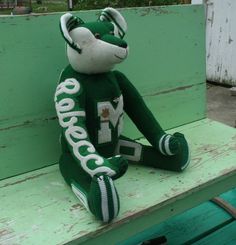 a stuffed animal sitting on top of a green bench