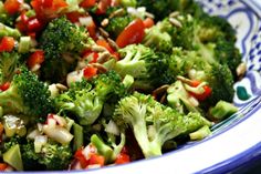 a blue and white bowl filled with broccoli and other vegetables