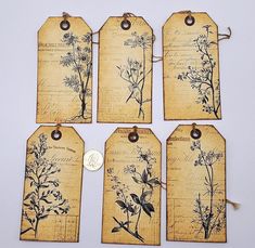 four tags with dried flowers on them