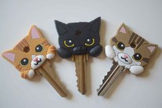 three keys with cats on them sitting next to each other in front of a white wall