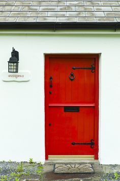 a red door is in front of a white house