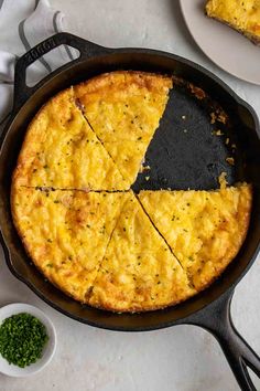 a skillet with some food in it and two plates on the table next to it