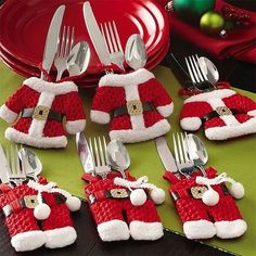 a table topped with silverware covered in santa clause hats and holding utensils