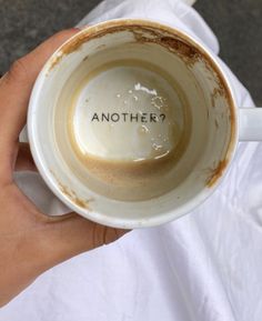 a person holding a coffee cup with the word another written on it