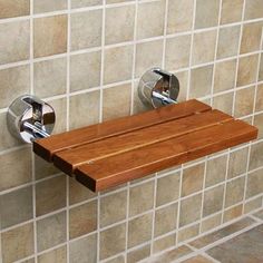 a wooden shelf mounted to the side of a tiled wall