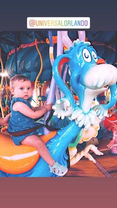 a little boy riding on top of a blue dragon ride