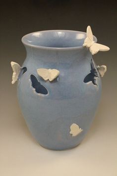 a blue vase with white butterflies on it