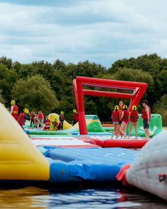 some people are standing on inflatable water toys