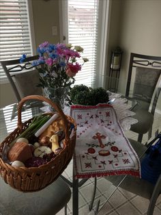 a table with a basket on top of it next to a vase filled with flowers