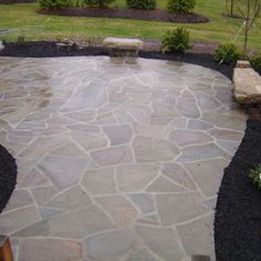 a stone walkway in the middle of a yard