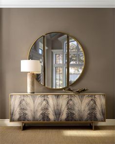 a living room with a large mirror on the wall next to a table and lamp