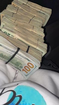 a pile of money sitting on top of a bed