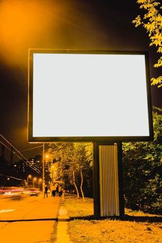 a large white billboard sitting on the side of a road next to a street light