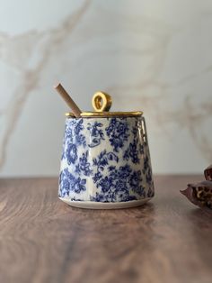 a blue and white cup with a cinnamon stick sticking out of it