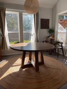 a living room with large windows and a round rug