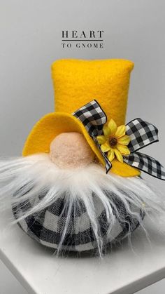 a yellow top hat with white feathers and a flower on the side, sitting on a table