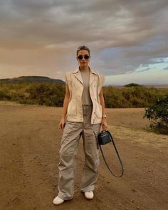 Elevate your safari experience with these casual and classy travel outfit essentials! Perfect for women traveling to South Africa, Tanzania, and Namibia, our guide features elegant and comfortable outfit ideas that are ideal for the wild, just like this chic safari outfit with grey cargo pants. Safari Outfit Women, Stylish Cargo Pants, Silk Shirt Outfit, Elevated Outfits, Cass Dimicco, Safari Outfit, Safari Outfits, Cargo Pants Outfits, Women Traveling