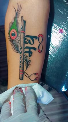 a woman's leg with a tattoo on it that has a feather and musical notes