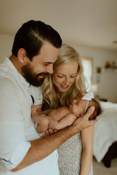 a man and woman holding a baby in their arms