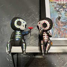 two skeleton figurines are sitting on a shelf