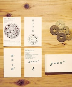 some type of business cards on top of a wooden table next to coins and paper