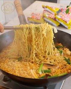 noodles being cooked in a wok with chopsticks