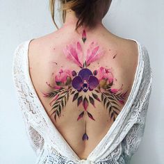 the back of a woman's neck with flowers painted on it