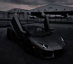 a black sports car parked in front of an airport