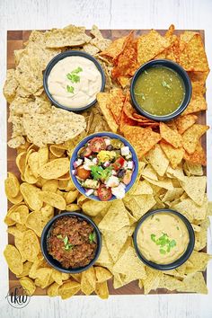 several different types of chips and dips on a cutting board