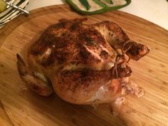 a whole chicken sitting on top of a wooden cutting board