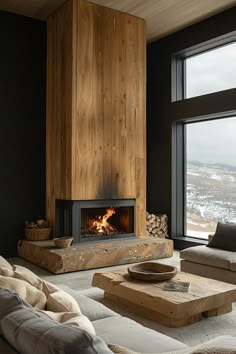 a living room filled with furniture and a fire place next to a large window on top of a wooden wall