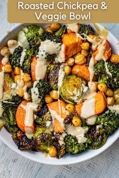 a white bowl filled with broccoli, carrots and chickpeas covered in dressing