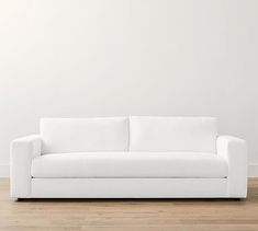 a white couch sitting on top of a hard wood floor