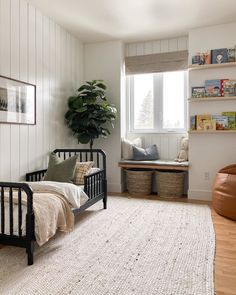 a bedroom with white walls and wooden floors