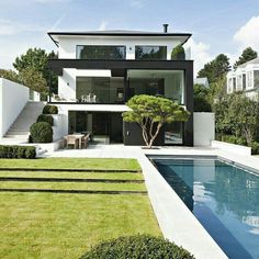 a modern house with a pool in the front yard and stairs leading up to it