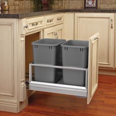 two plastic bins in the middle of a kitchen cabinet with wooden floors and white cabinets