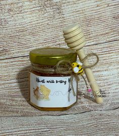 a jar of honey with a wooden stick sticking out of it's side on a table